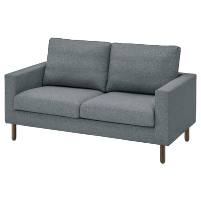 Un divano grigio SALTSJÖBADEN . Ha un design elegante e moderno con cuscini rettangolari e gambe di legno, offrendo un'opzione di seduta accogliente ma elegante.