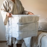 Persona che tiene la scatola di immagazzinaggio SAMLA con coperchio con chiusura a scatto.