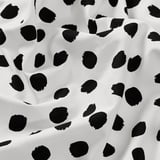 Tessuto bianco e nero con grandi motivi a tampone; trama di cotone di alta qualità, adatta per progetti di cucito.