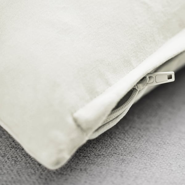 Primo piano della morbida fodera del cuscino bianco con cerniera liscia; texture in velluto di cotone di alta qualità.