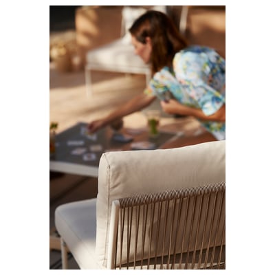 Sedia da esterno moderna bianca con cuscino beige, struttura in acciaio, design elegante.