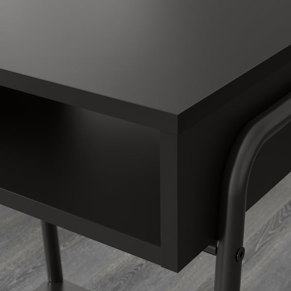 Comodino moderno nero con eleganti gambe in metallo e superficie liscia.