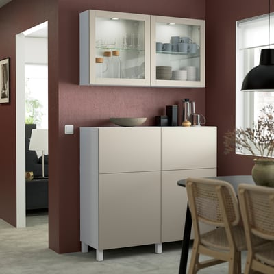 Credenza SINDVIK in grigio chiaro-beige, con ante in vetro, si inserisce sotto i pensili. Espositori di parabole ed elettronica, dal design moderno.