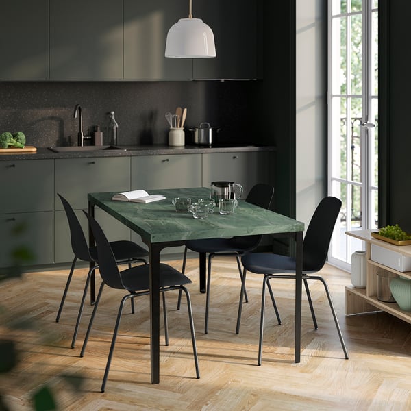 Tavolo verde SKÅLSTA con sedie nere in cucina moderna, vicino alla finestra.