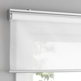 Una tenda a rullo senza fili con chiusura ammortizzata, montata sopra una finestra, che consente luce filtrata e sicurezza.