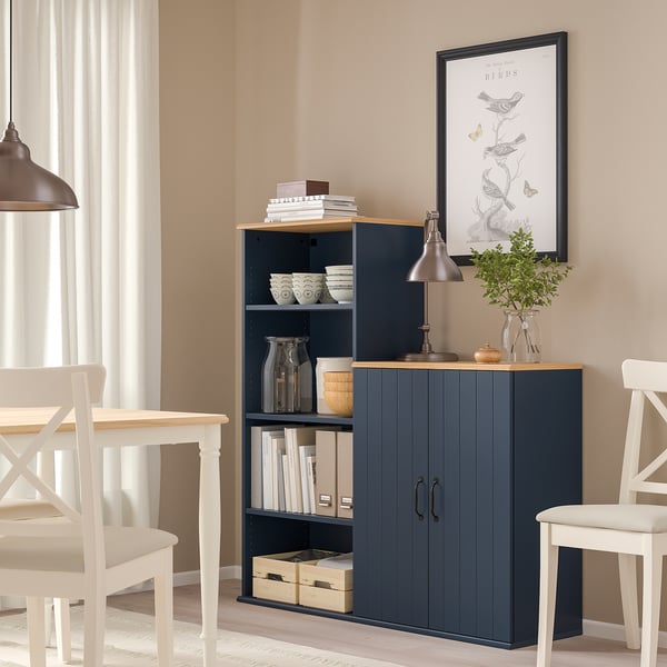 Madia SKRUVBY blu navy, mensole a giorno, lampada, libri, tra le sedie.