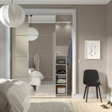 Camera da letto moderna con ampio armadio a specchio SKYTTA, luci soffuse e letto.