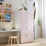 Camera dei bambini con cassetti SMÅSTAD rosa, sgabello in legno, libreria, scrivania con lampada e giocattoli.