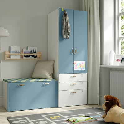 Cameretta per bambini con contenitore SMÅSTAD blu-bianco, panca imbottita, ripiano in legno, peluche, tappeto, grande finestra.