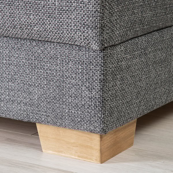 Primo piano di un angolo divani moderno, che mette in mostra il suo tessuto robusto e l'elegante gamba in legno.