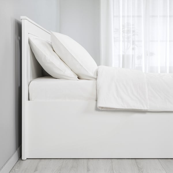 Camera da letto pulita con pouf letto bianco SONGES con biancheria da letto riposta, che mette in mostra il suo pratico contenitore sotto la rete a doghe.