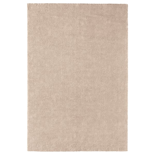 Un tappeto beige ikea STOENSE con un pelo morbido e spesso, che offre comfort e calore. Ha una lucentezza chiara, una forma rettangolare e un bordo liscio.