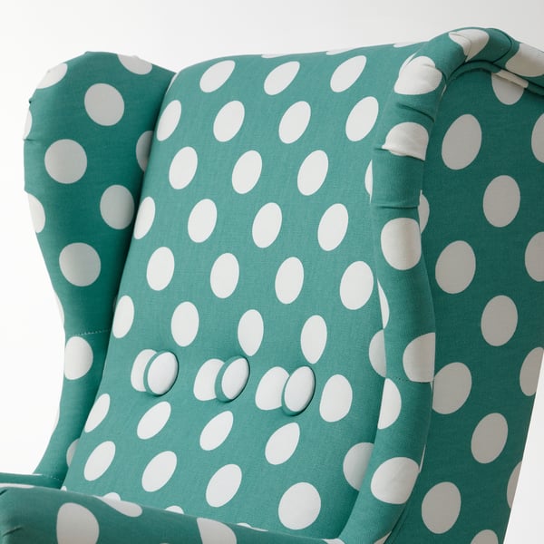 Primo piano di una poltrona per bambini turchese a pois, che evidenzia morbide, cuciture dettagliate e design robusto.