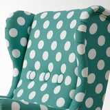 Primo piano di una poltrona per bambini turchese a pois, che evidenzia morbide, cuciture dettagliate e design robusto.