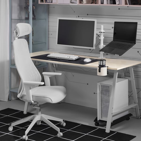 Scrivania moderna e minimalista con sedia STUBBERGET bianca, monitor bianco e laptop in bianco e nero su supporto. Look pulito e organizzato.