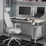 Scrivania moderna e minimalista con sedia STUBBERGET bianca, monitor bianco e laptop in bianco e nero su supporto. Look pulito e organizzato.