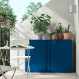 Scena del balcone con armadio SUNDSÖ blu, piante in vaso e sedie bianche.