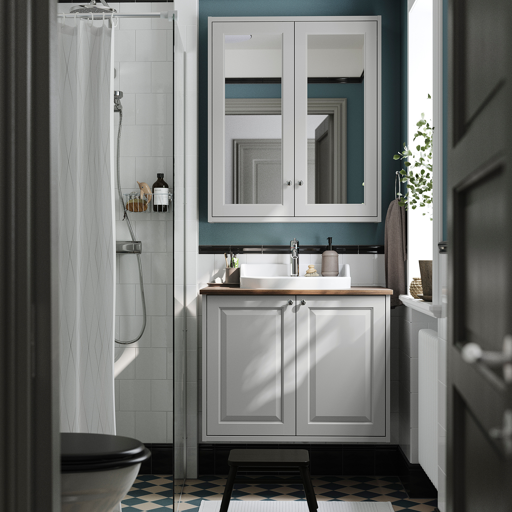Bagno moderno con lavabo grigio TÄNNFORSEN, accenti azzurri, lavandino bianco e pavimento con motivi in bianco e nero.