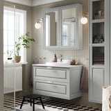 Bagno moderno con lavabo TÄNNFORSEN, specchio, sanitari cromati, pavimento bianco/nero, radiatore bianco.