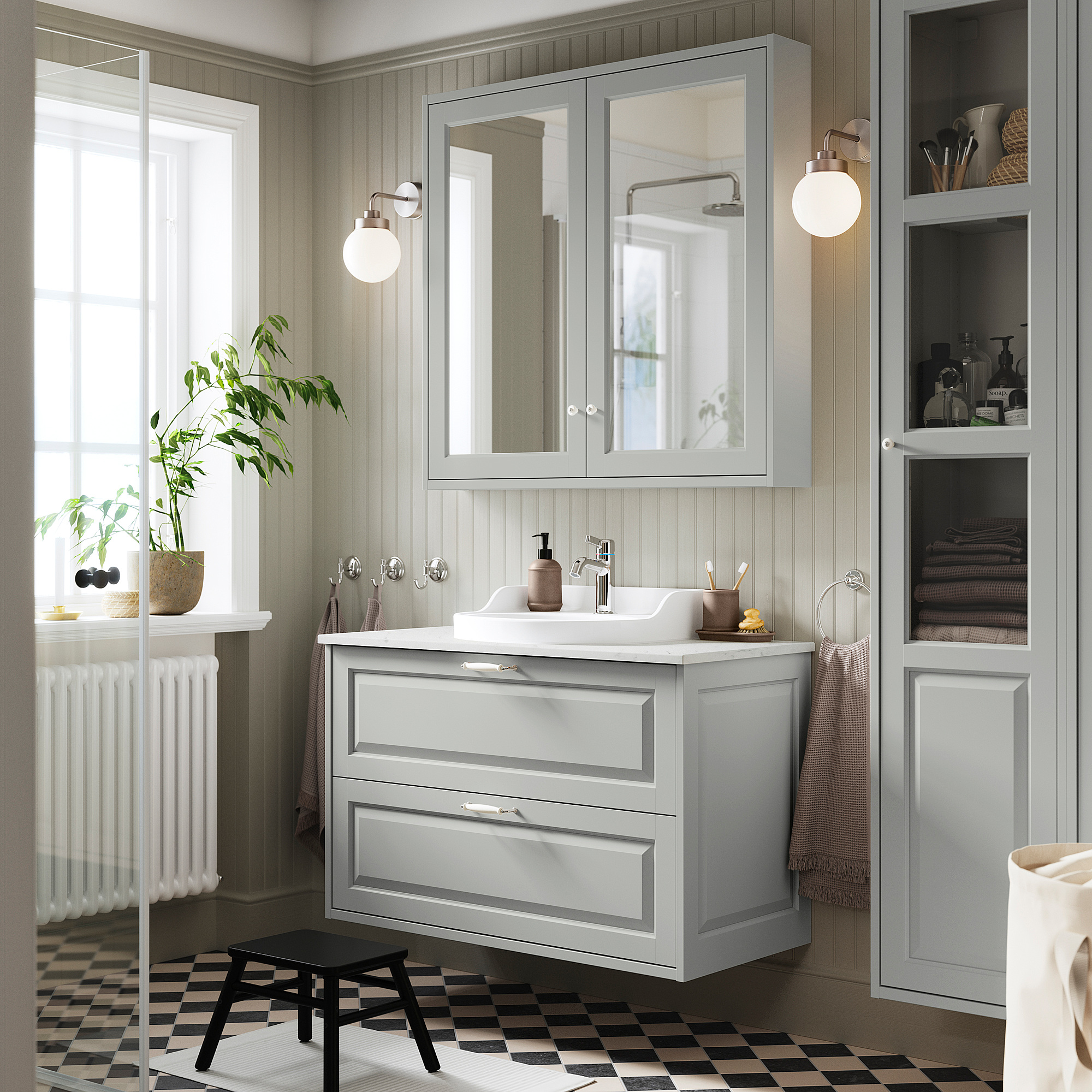 Bagno moderno con lavabo TÄNNFORSEN, specchio, sanitari cromati, pavimento bianco/nero, radiatore bianco.