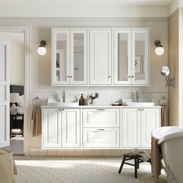 Vanity TÄNNFORSEN bianco con grandi specchi, due lavandini, sanitari cromati e piano in ceramica. Spaziosi vani portaoggetti, asciugamani e tavolino migliorano l'aspetto moderno.