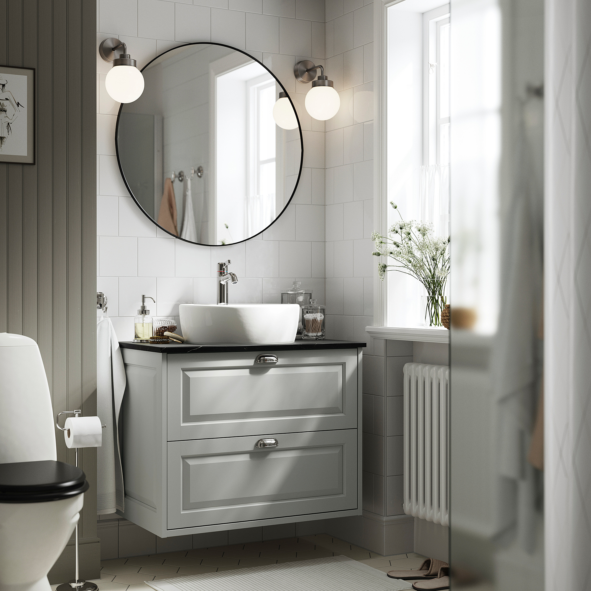 Moderno mobile da bagno grigio TÄNNFORSEN con lavandino, specchio, luci e cassetti, oggetti essenziali e vaso; WC parziale.