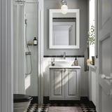 Un bagno moderno con armadietto bianco TÄNNFORSEN, elegante lavandino, specchio e doccia in vetro.