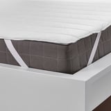 Coprimaterasso bianco sul letto, cinghie elastiche per una vestibilità sicura, protegge il materasso dalle macchie.