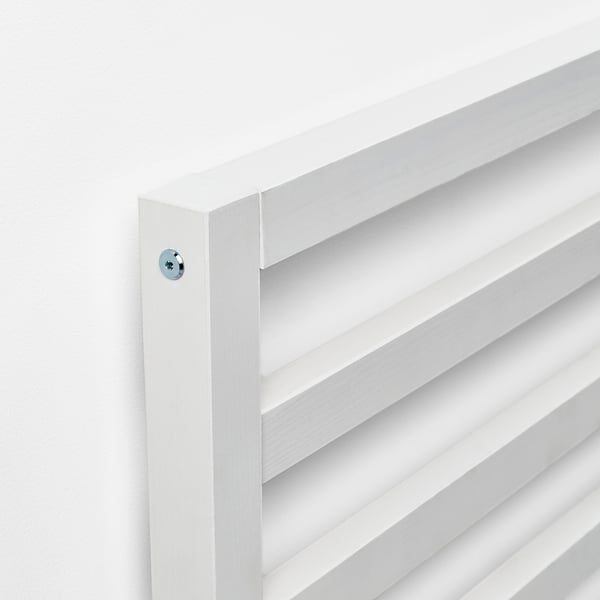 Testiera in legno bianco con linee pulite e viti a vista.