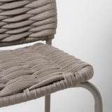 Sedia moderna in vimini, seduta e schienale in polipropilene intrecciato, gambe in metallo curvato.