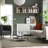 Soggiorno moderno con tappeto in lana TIDTABELL, pareti verde scuro, mobili chiari, piante.