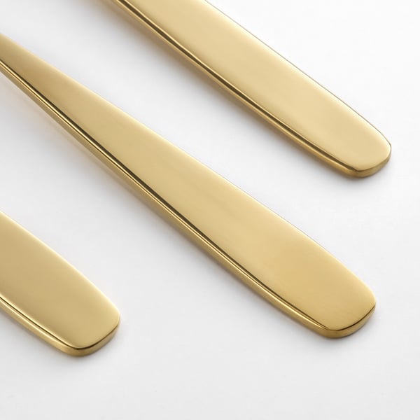 Utensili d'oro, lucidi e lucenti, disposti ordinatamente. Design elegante, finiture di alta qualità.