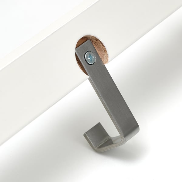 Robusto gancio in metallo su staffa in legno con vernice bianca. Regolabile per appendere gli accessori.