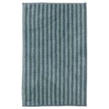 Un tappetino da bagno TOFTBO in blu, rettangolare, con una superficie strutturata e morbida. Realizzato in poliestere riciclato.