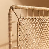 Dettaglio angolare della testiera in rattan intrecciato. Mostra un'intricata lavorazione artigianale con fibre naturali.