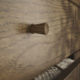 Gancio in legno su superficie in legno invecchiato e strutturato; aspetto naturale e rustico.