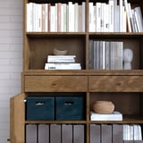 Libreria in legno con libri, oggetti decorativi e contenitori per la conservazione. Ripiani regolabili.
