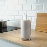 Portarotolo da cucina in argento con una barra di supporto su un bancone di legno, che tiene un rotolo di carta bianca.