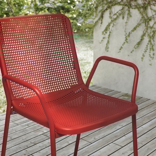 Sedia da esterno di colore rosso brillante con sedile e schienale traforati, robusta struttura in metallo, ideale per un uso durevole e a bassa manutenzione.