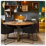 Moderna sala da pranzo con sedie TOSSBERG, tavolo in legno scuro e sedili in pelle nera. Parete verde e mensole.