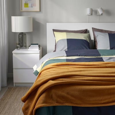 Il copriletto Tatticevia oro copre il letto grande, morbido pile, si abbina ai cuscini colorati.