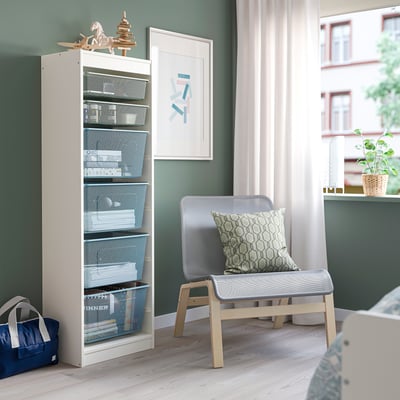 Scaffali TROFAST con scatole, sedia e scena.