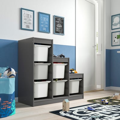 Cameretta per bambini con portaoggetti TROFAST grigio e bianco, macchinina da parete, cesto della biancheria, scatole bianche multiple.
