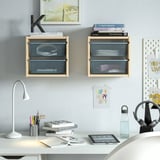 Scatole TROFAST da parete sopra la scrivania con libri, lampada, tablet, borraccia, cuffie.