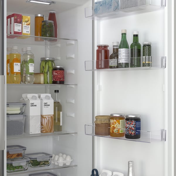 Frigorifero ben organizzato con più ripiani e scomparti, che mostra prodotti alimentari come bottiglie, barattoli e prodotti, indicando una conservazione efficiente.