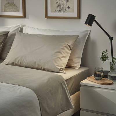 Camera da letto moderna con cuscini ULLVIDE, lampada, vetro, vaso.