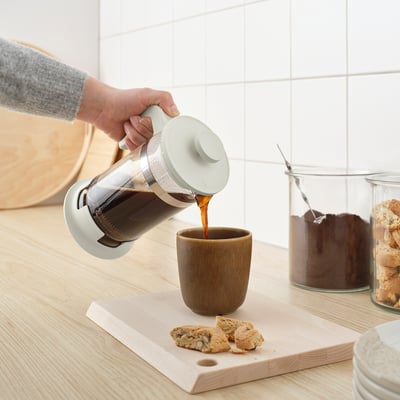 Versare il caffè fresco dalla caffettiera/macchina per il tè UPPHETTA in una tazza.