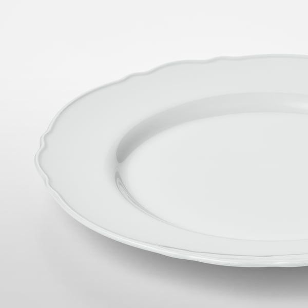 Elegante piatto in porcellana bianca pura con delicato bordo arricciato. Superficie liscia e di alta qualità. Lavastoviglie.