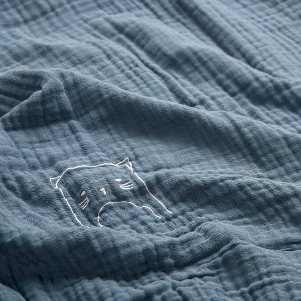 Morbido fasciatoio blu in cotone organico, dettaglio gatto ricamato, texture di alta qualità.