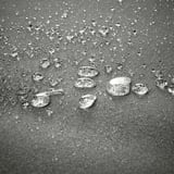 Gocce d'acqua sul tessuto. La scatola VÄTTERSÖ mantiene i cuscini asciutti e freschi.